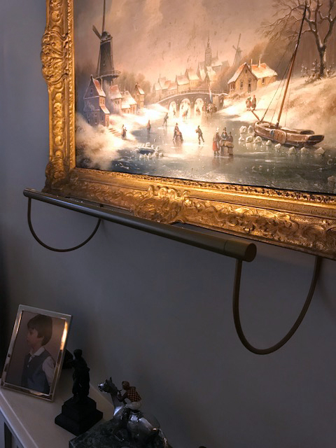 private client under hanging picture light on oil painting